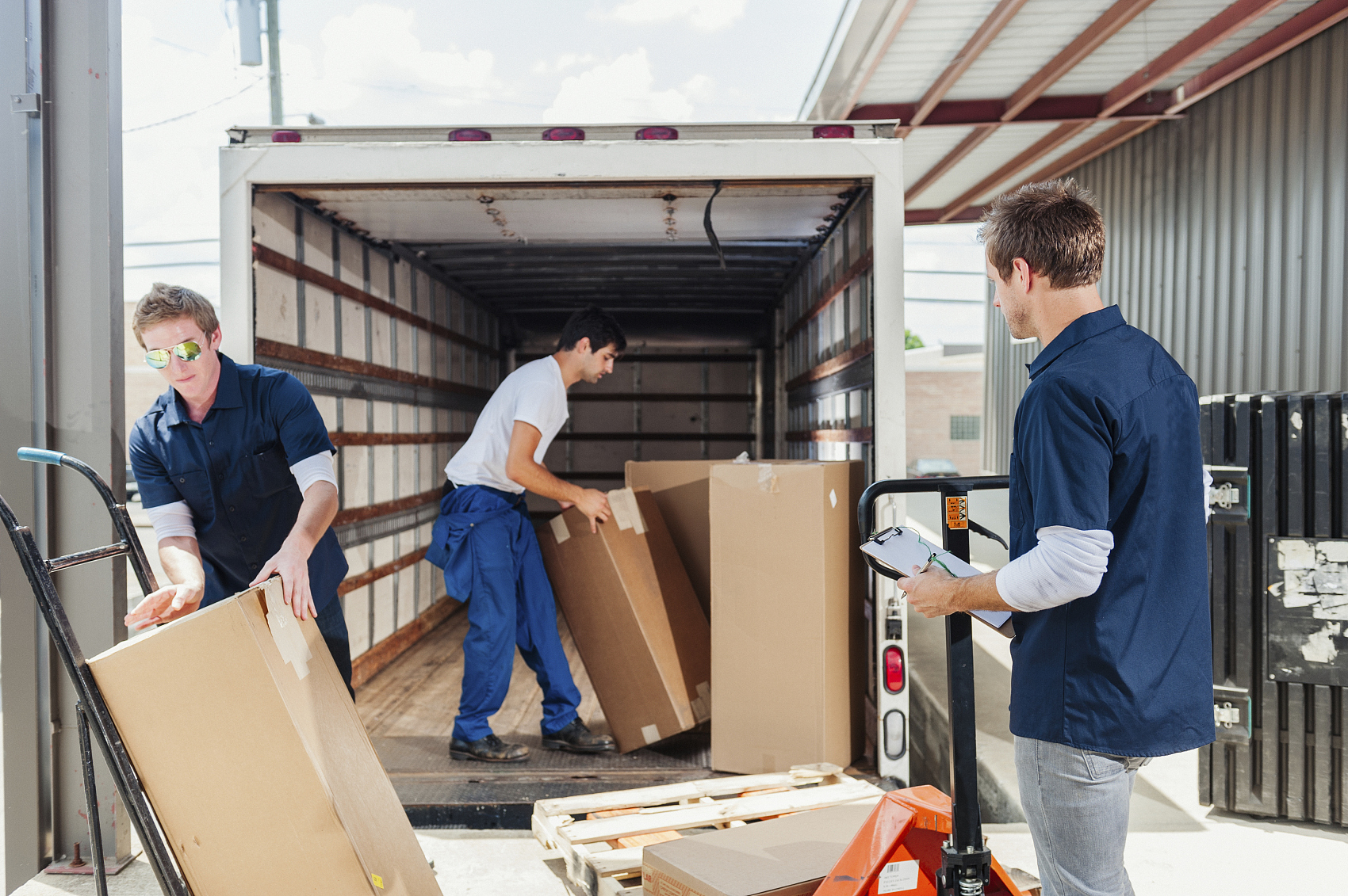 Oversized furniture being loaded onto a flat rack container at a port