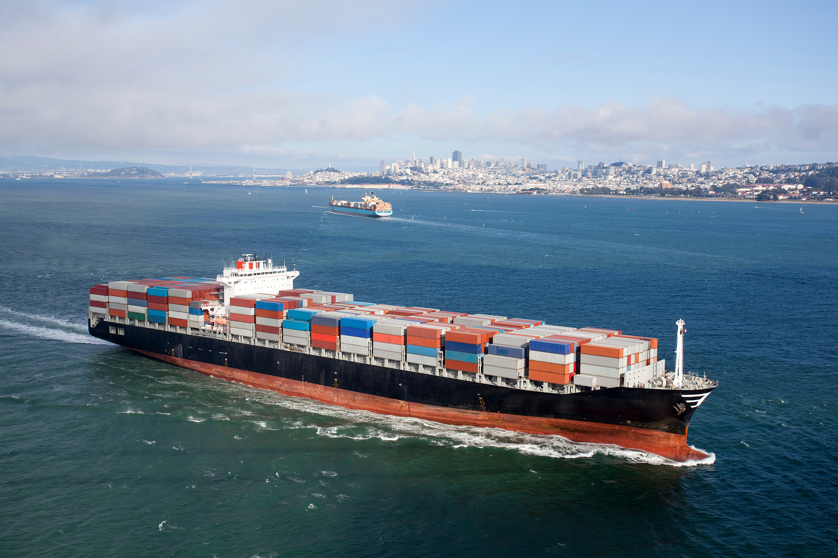 Large container ship departing from a bustling Chinese port