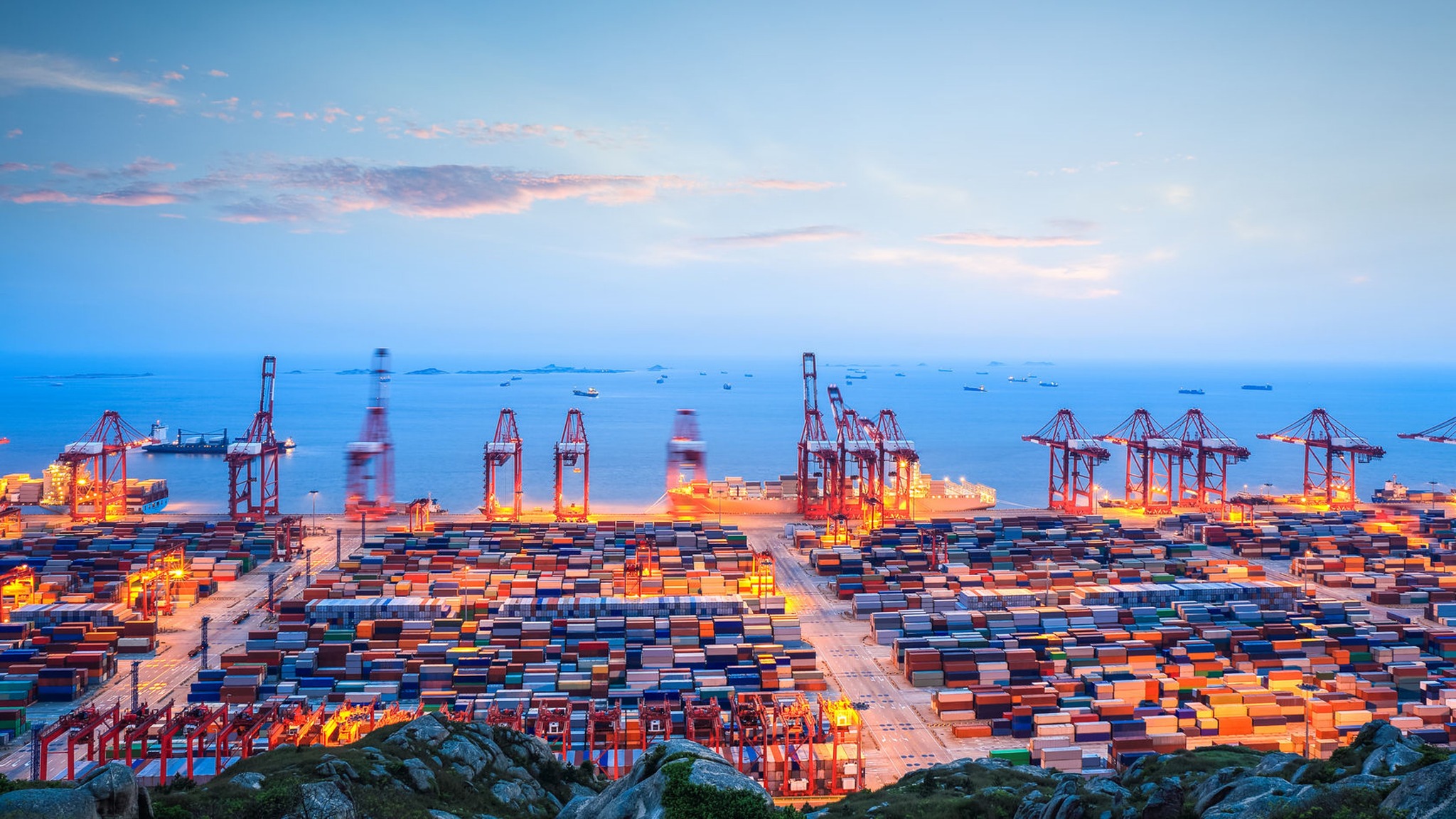 Container ship loaded with 40HQ FCL containers at a busy port, symbolizing solar panel shipments from China to France